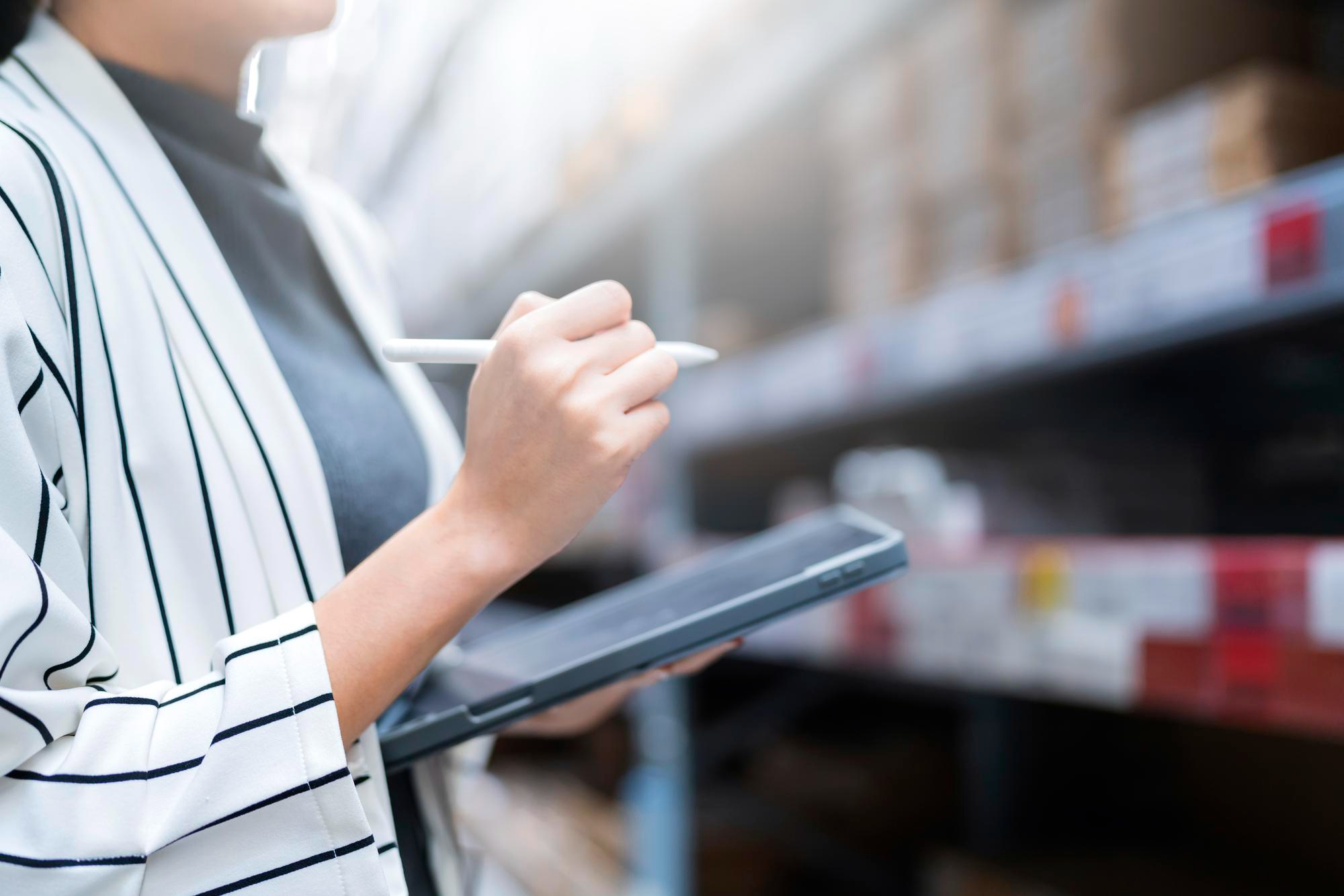 close-up-female-business-owner-hand-hold-tablet-device-checking-inventory-stock-shop-warehouse-distributor-factory-business-ideas-concept (1)